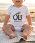 Baby wearing Ocean Beach Parrot bodysuit at Ocean Beach in San Diego