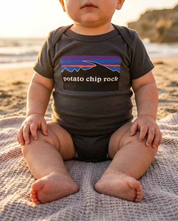Baby wearing Potato Chip Rock bodysuit on a San Diego beach at golden hour