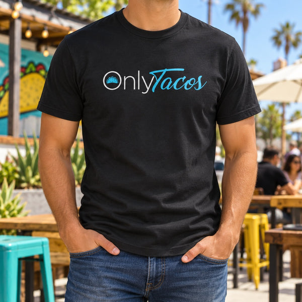 Man wearing a black Only Tacos T-shirt on a taco shop patio with a taco mural and palm trees