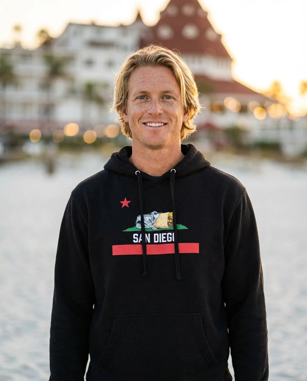 Person wearing San Diego Burrito Flag Hoodie - Unisex at Coronado Beach in San Diego