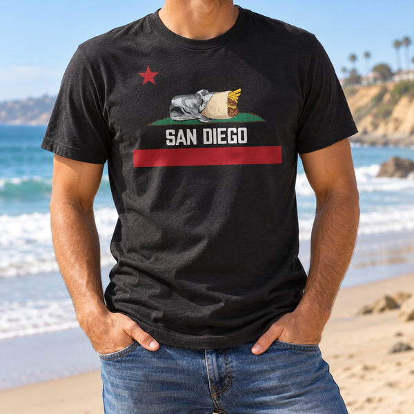 Man on the beach in a black San Diego Burrito flag T-shirt with a California burrito, red star and red stripe