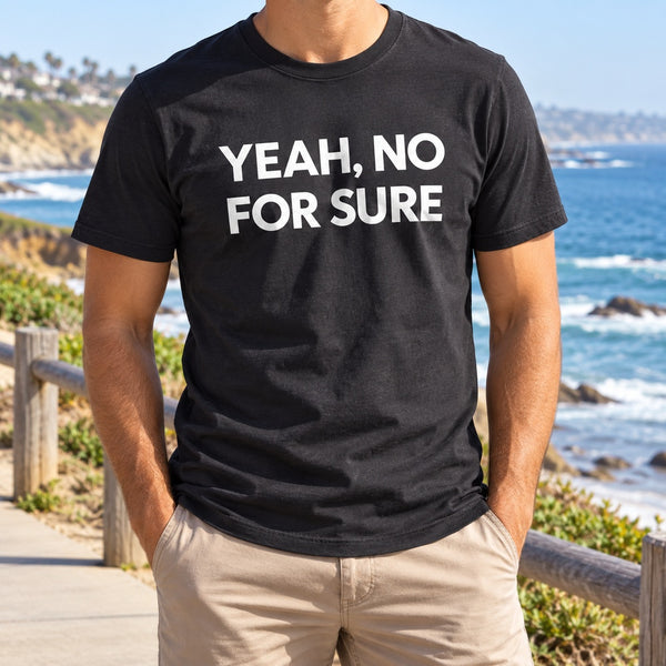 Man in a black Yeah, No For Sure T-shirt on a coastal path above the ocean