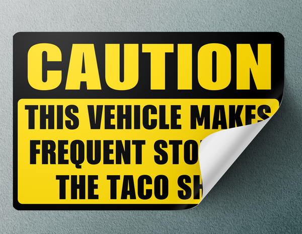 Caution Frequent Stops At The Taco Shop Bumper Sticker Mockup - Yellow Caution Taco Shop Vinyl Sticker Peeling Corner Detail Angled View | San Diego Humor